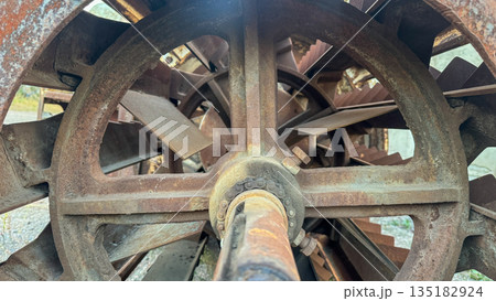 Heavy industrial rusted metal machine with paddles and chain drive. Heavy industrial rusted metal machine with paddles and chain drive. 135182924