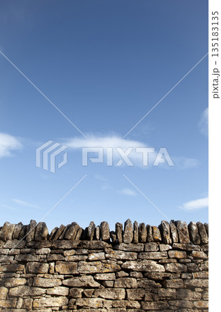 Part of a traditional stone enclosure with a blue sky in the background Part of a traditional stone enclosure with a blue sky in the background 135183135
