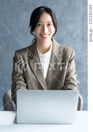 オフィスでノートパソコンを使う女性 オフィスでノートパソコンを使う女性 135183165