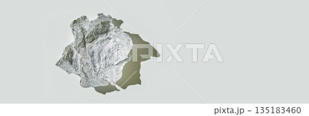 Crumpled aluminum foil ball casting shadow on light gray surface 135183460