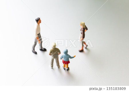 ミニチュアの子どもたちの前で向き合う男女 父母 親子 親権 イメージ 135183809