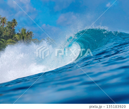 Blue wave breaking on a beach in sea Blue wave breaking on a beach in sea 135183920