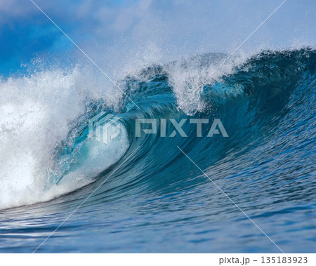 Blue wave breaking on a beach in sea Blue wave breaking on a beach in sea 135183923