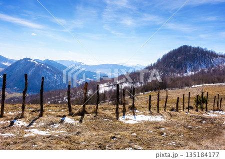 snow covered hill with barbed wire fence on a sunny day. green environment sustainability and protection. background for earth day snow covered hill with barbed wire fence on a sunny day. green environment sustainability and protection. background for earth day 135184177