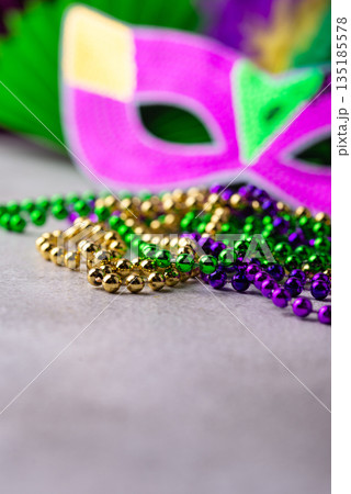 Vibrant Mardi Gras background with mask, beads, and festive decorations 135185578