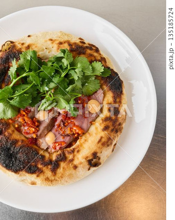 Rustic sourdough base topped with chili and onion accents 135185724