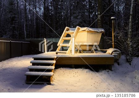 Secluded alpine hot tub area with glowing warm ambiance 135185786