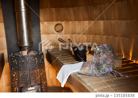 Traditional Sauna With Cozy Glow, Authentic Steam Bath Setup Featuring Timeless Wooden Benches And Heaters Traditional Sauna With Cozy Glow, Authentic Steam Bath Setup Featuring Timeless Wooden Benches And Heaters 135185838