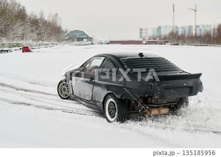 Coupe glides across snowcovered course with aggressive rear wheel slide 135185956