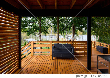 Cozy rustic patio featuring privacy screen and comfortable seating 135185958