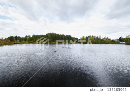 Calm muted lake reflecting autumn sky with gentle waves Calm muted lake reflecting autumn sky with gentle waves 135185963