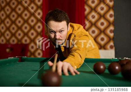 Caucasian player executing finishing shot in retro interior 135185988