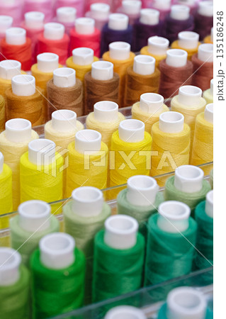 Many spools of thread of different colors 135186248