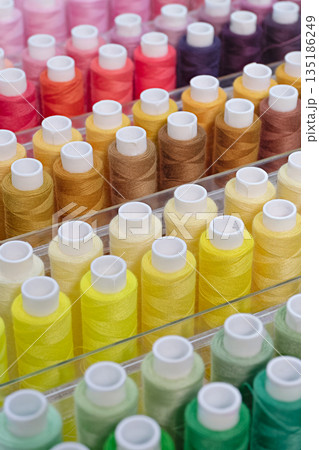 Many spools of thread of different colors 135186249