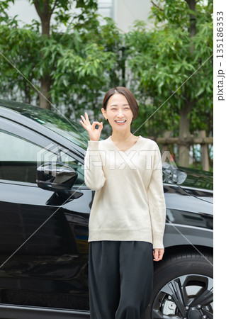 車の前に立つ女性 135186353