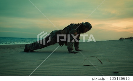 American Navy soldier does push-ups on the beach at sunset for sports training 135186616