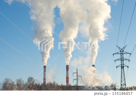 Chimneys of traditional thermal power plant generating heat, steam, and smog. Environmental concept 135186857