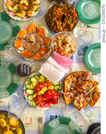 Colorful spread of assorted dishes on table with vibrant plates and glasses Colorful spread of assorted dishes on table with vibrant plates and glasses 135186870