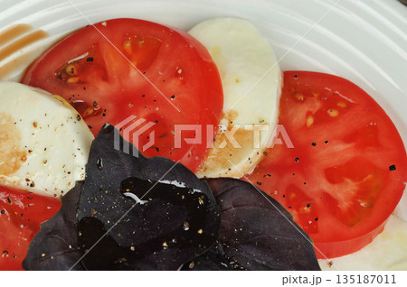 Caprese salad - tomatoes, basil and mozzarella cheese 135187011