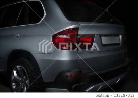 Rear of the car with a taillight close-up in black background Rear of the car with a taillight close-up in black background 135187312