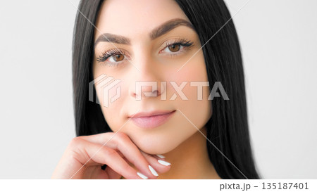 Face smooth skin. Healthy glow. Young female touching chin. Calm girl demonstrating natural wellness beauty makeup isolated on white. Face smooth skin. Healthy glow. Young female touching chin. Calm girl demonstrating natural wellness beauty makeup isolated on white. 135187401