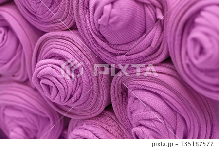 Knitted pink fabric rolled into rolls 135187577