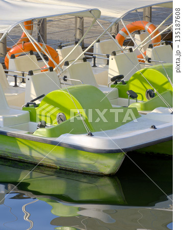 Green catamarans at the pier in the amusement park Green catamarans at the pier in the amusement park 135187608