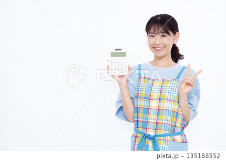 電卓を持ってピースサインをしている主婦 135188552