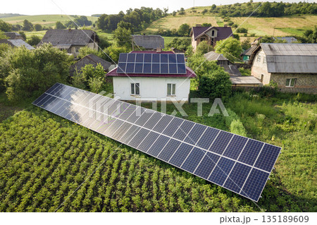 Aerial view of a house with blue solar panels for clean energy. Aerial view of a house with blue solar panels for clean energy. 135189609