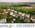 Aerial landscape of small town or village with rows of residential homes and green trees. 135189659