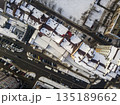 Aerial black and white winter top view of modern city with tall buildings, parked and moving cars along streets with road marking. Urban cityscape, view from above. 135189662