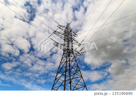 A striking power tower silhouette stands tall against a backdrop of a dramatic, cloudy sky 135190890