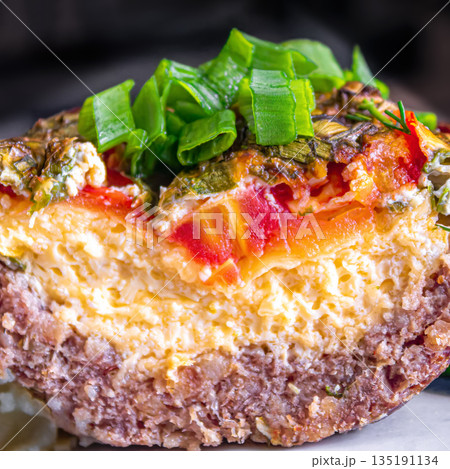 Fresh baked meat with cheese and tomatoes topped with chopped green onions 135191134