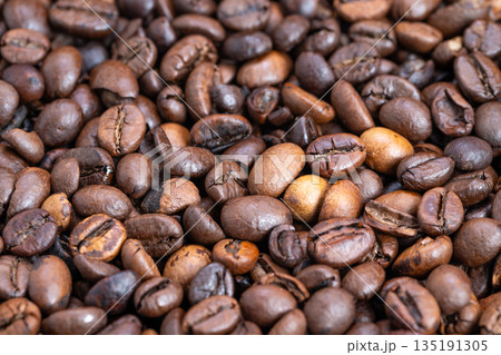 Closeup macro coffee bean textures highlighting micro cracks and oil droplets, surface sheen and tactile detail for sensory marketing and high-detail product photography 135191305