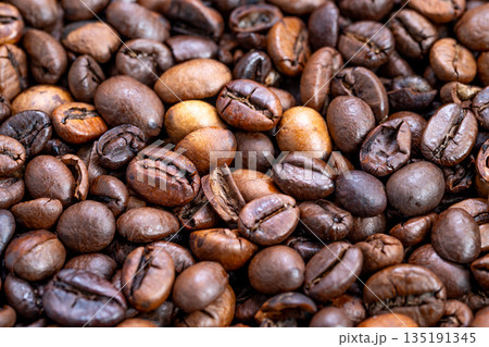 Varied roasted coffee bean display, Warm industrial atmosphere with roasted beans, Detailed shot of mixed roast coffee beans emphasizing craft and industrial ambiance 135191345
