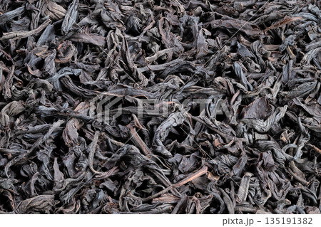 Tea leaf closeup, Close investigation of tea leaves, Detailed examination of fragrant black tea leaves, Detailed view highlighting aroma and texture of twisted tea leaves Tea leaf closeup, Close investigation of tea leaves, Detailed examination of fragrant black tea leaves, Detailed view highlighting aroma and texture of twisted tea leaves 135191382