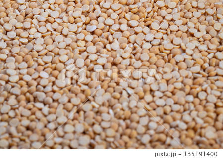 Uniform pile of yellow split peas prepared for packaging and sale, Freshly sorted yellow split peas arranged neatly in bulk for commercial distribution and purchase 135191400