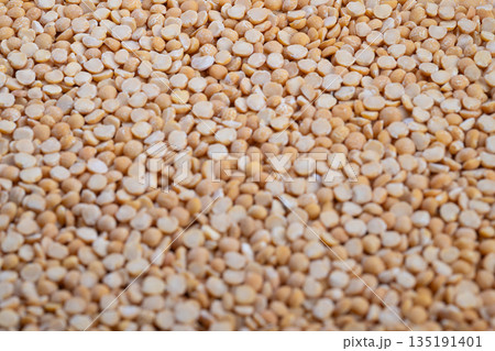 Closeup yellow split peas showcased as plant protein source, firm dry kernels, highprotein vegan staple, textured surface suitable for nutrition blogs and labels 135191401