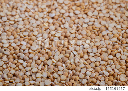 Highquality imagery of peas emphasizing surface details and purity, Closeup photo showcasing individual yellow peas with surface features and possible impurities 135191457