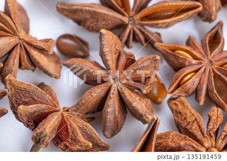 Detailed spice closeup, Highresolution image capturing glossy star anise pods and seeds, Closeup photograph emphasizing gleaming seeds and warm tones of star anise pods 135191459