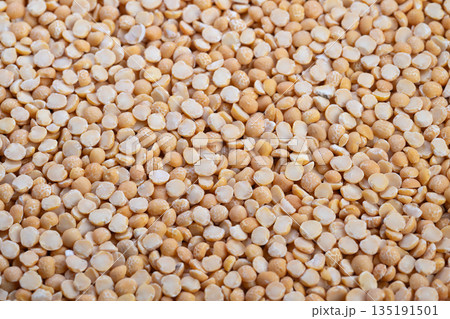 Macro view yellow split peas filling frame, warm earthy tones, scattered groats showing raw uncooked legumes, natural protein and fiber, ideal for soup and stew concepts 135191501