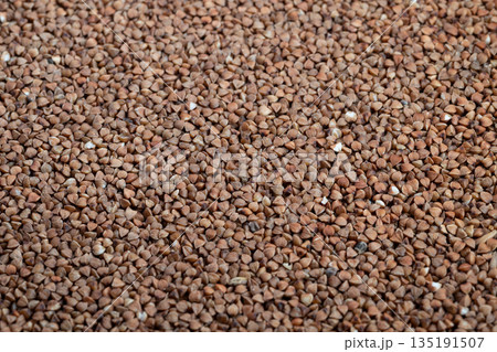 Closeup of buckwheat grains, Detailed view of dry buckwheat kernels, Presentation of buckwheat groats highlighting organic texture and artisanal baking qualities 135191507