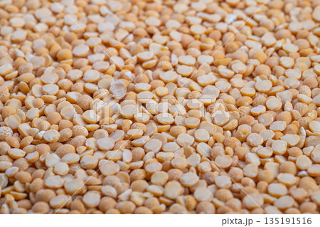 Heaped split peas ready for soup, cozy kitchen mood with implied home cook stirring pot, warm lighting suggesting comfort meal, traditional recipe ingredient focus 135191516