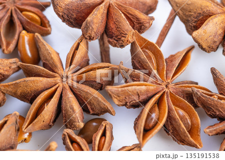 Warm star anise pods evoke holiday baking scene, cozy atmosphere with spice notes, textured pods and glossy seeds suggesting infusion into seasonal recipes and festive desserts 135191538