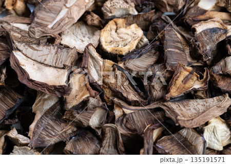 Overlapping mushroom slices with shadows, Dried mushrooms with textured surface and shadow effects, Closeup of dried mushrooms displaying contrasting shapes and tactile details Overlapping mushroom slices with shadows, Dried mushrooms with textured surface and shadow effects, Closeup of dried mushrooms displaying contrasting shapes and tactile details 135191571
