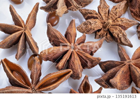 Minimalist star anise showcase with subtle shadows and textures, Sleek and simple presentation of star anise on plain white surface emphasizing textures and shadows 135191613