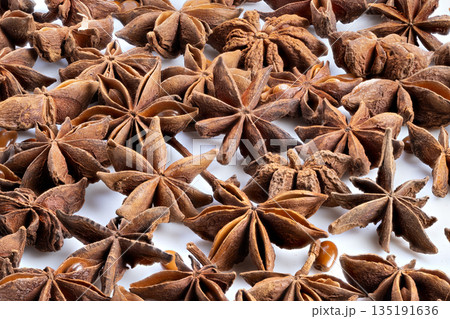 Anise seeds closeup, Detailed image of anise spice in rustic studio setting, Close perspective of anise pods and seeds against warm rustic background with rich textures Anise seeds closeup, Detailed image of anise spice in rustic studio setting, Close perspective of anise pods and seeds against warm rustic background with rich textures 135191636