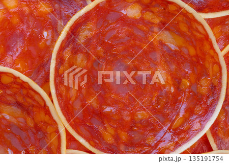 Grocery chorizo closeup for label photography, cured sausage slices showing marbling and color fidelity suited for retail packaging and online product catalogues 135191754