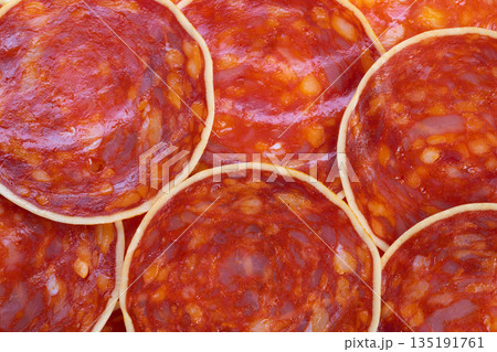 Slices of chorizo prepared with cheese and spices for cooking, Thin slices of cured chorizo arranged deliciously for oven baking with cheese and aromatic seasonings 135191761