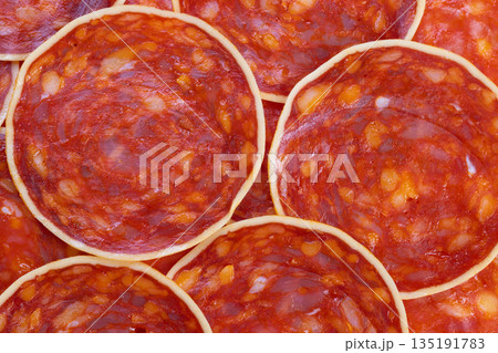Chorizo slices display, Detailed closeup of chorizo slices emphasizing rind and marbling, Highresolution image showcasing layered chorizo pieces with studio lighting effects Chorizo slices display, Detailed closeup of chorizo slices emphasizing rind and marbling, Highresolution image showcasing layered chorizo pieces with studio lighting effects 135191783